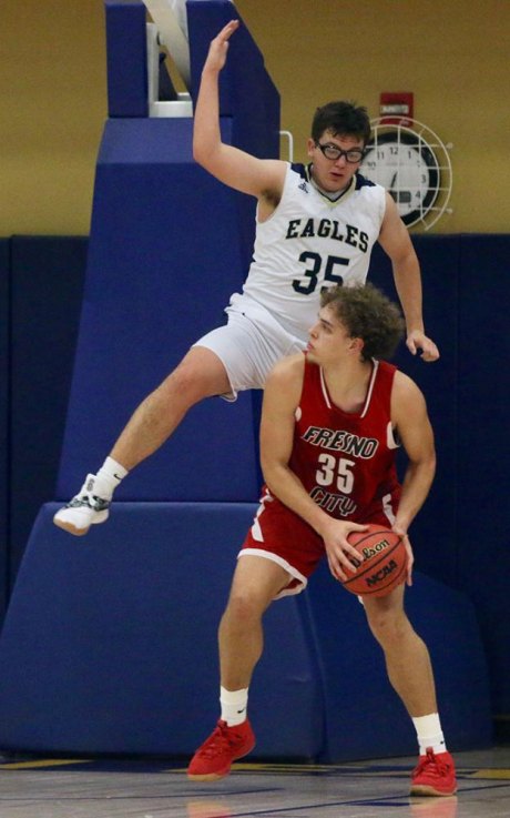 West Hills College Lemoore's Bryce Hernandez blocks a shot by Fresno City College's Ethan Richardson in the first half of Thursday's basketball game with Fresno City College.